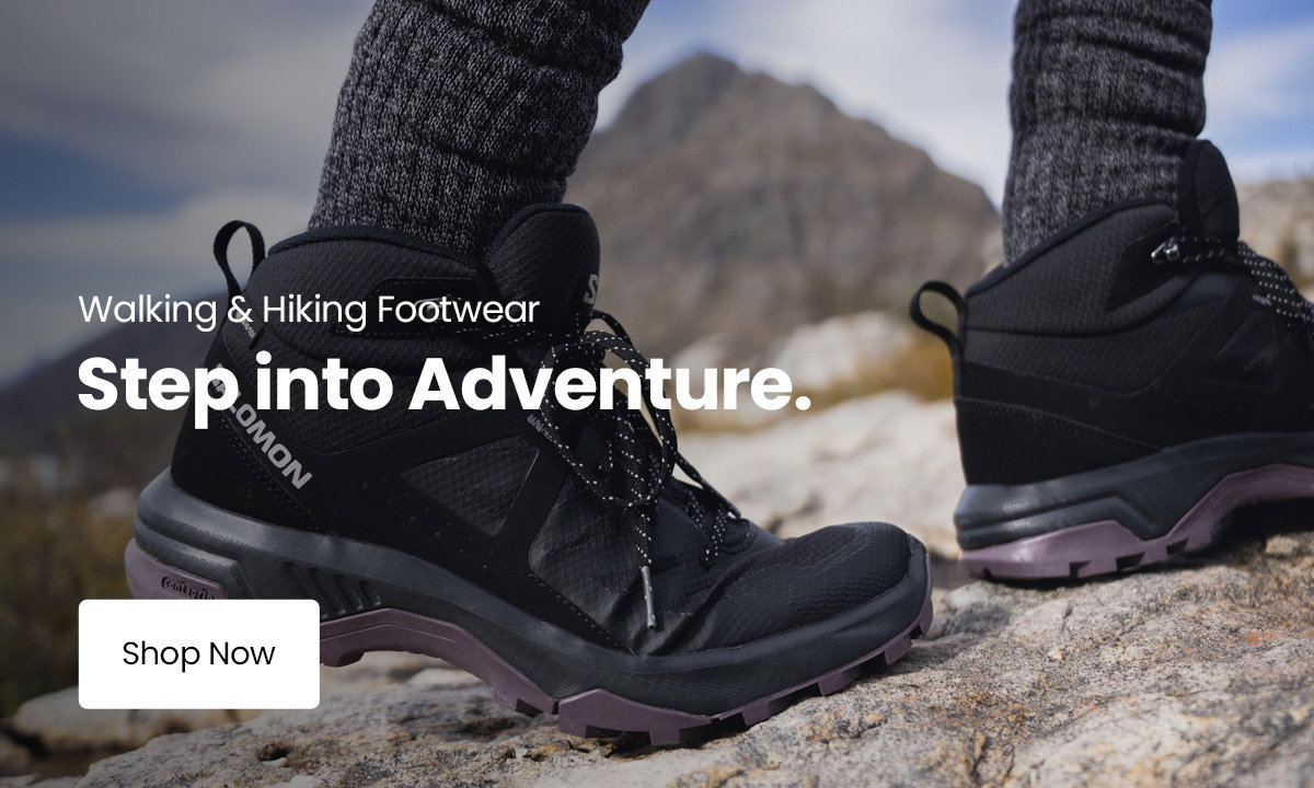Black Salomon hiking boots standing on rocky mountain terrain with the text “Walking & Hiking Footwear. Step into Adventure.” and a “Shop Now” button.