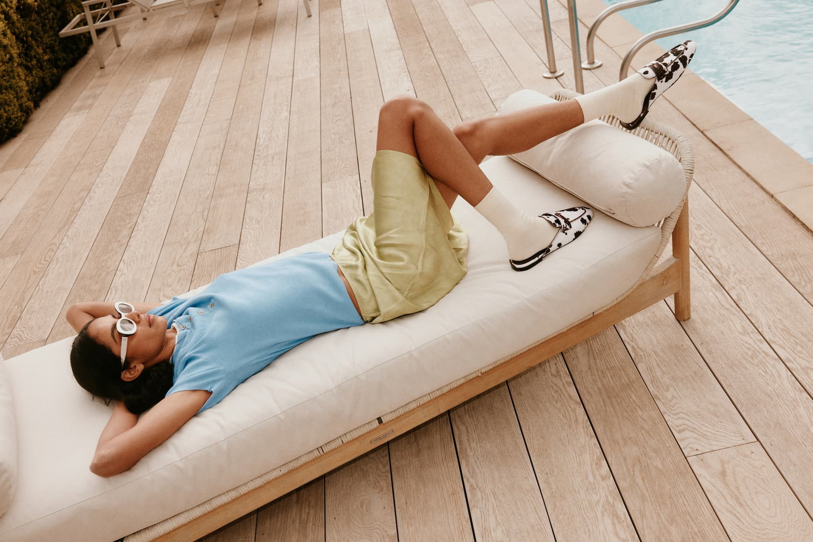 Model wearing white bamboo socks by a swimming pool