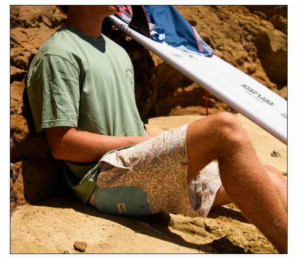 Surfer wearing Laybacks and a Billabong tee at the beach