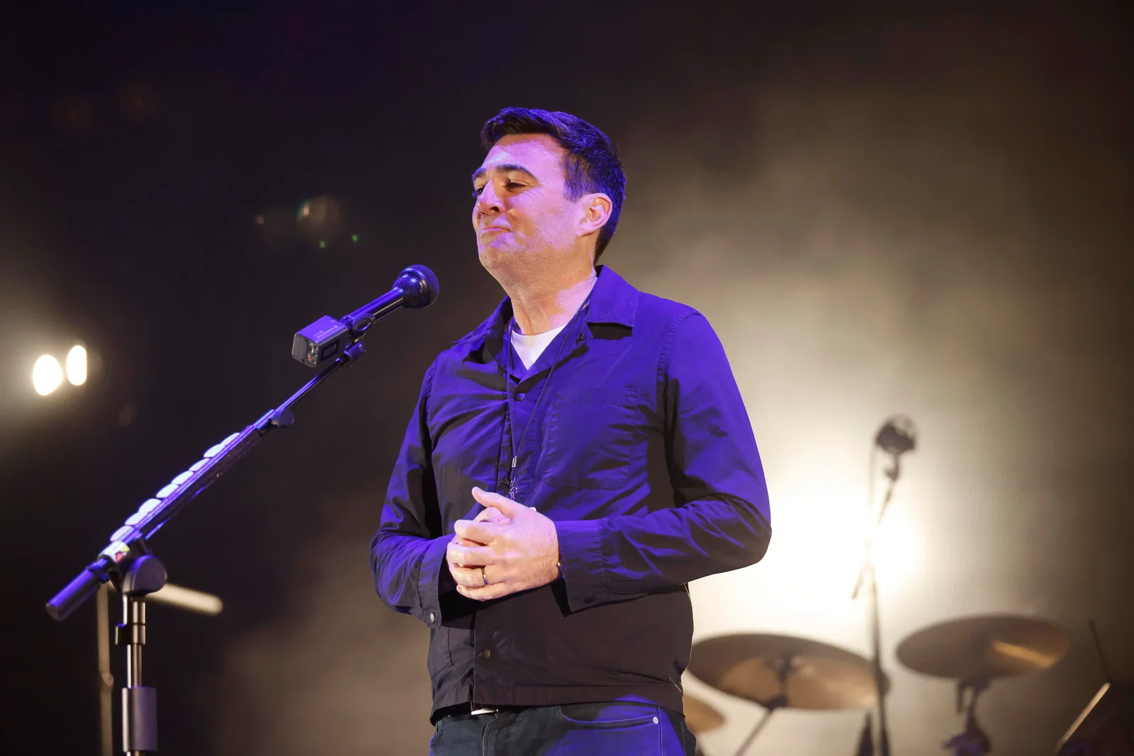 Andy Burnham, new British prime minister, shown standing on a stage with a microphone.