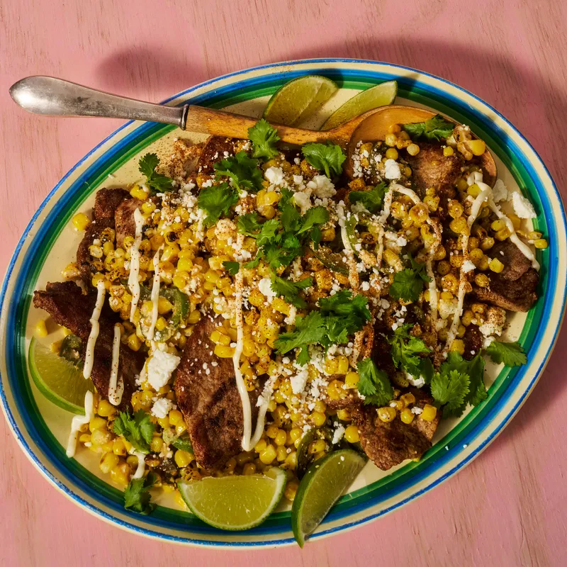 Street Corn Chicken and Pork Stir Fry plated on a green lined plate