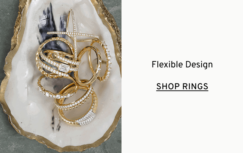 An oyster shell holding a pile of diamond and gold stacking rings. Flexible design. Click to Shop Shy Creation Rings