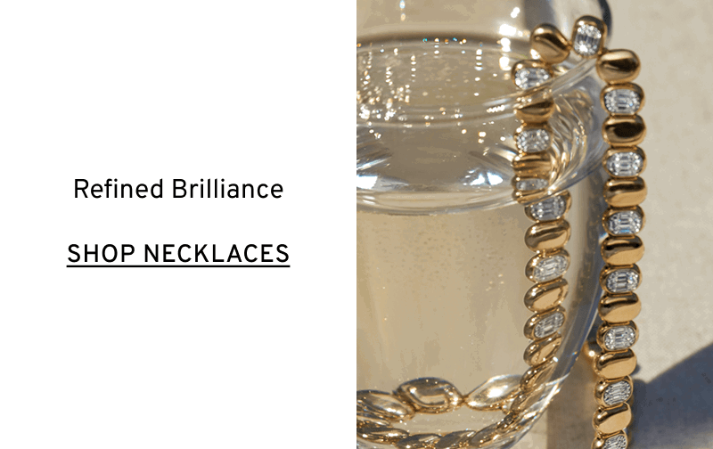 A chunky gold and diamond necklace draped over a glass of water. Refined brilliance. Click to Shop Shy Creation Necklaces