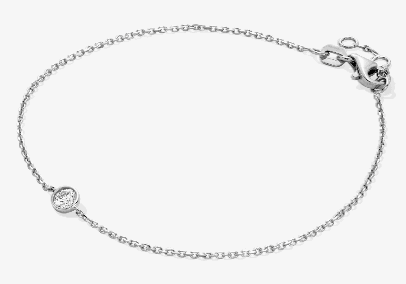 White metal bracelet featuring a bezel-set round diamond.