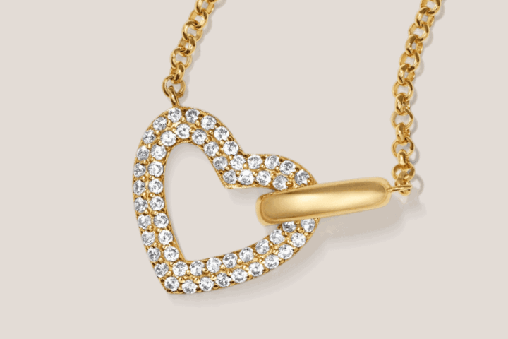 Yellow gold open heart-link pendant with pavé diamond details on dainty chain.