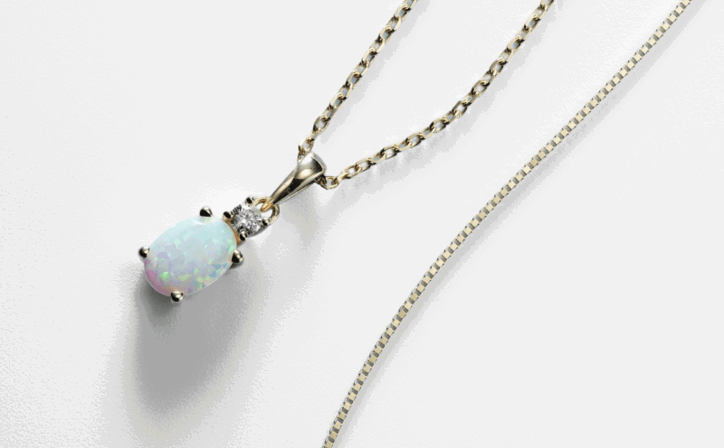 Oval opal pendant necklace with a round diamond accent.