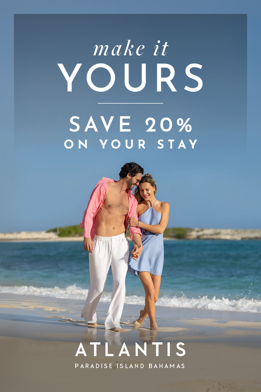 Make It Yours: Save 20% On Your Stay at Atlantis Bahamas. | A smiling couple holding hands walks along the shoreline of a white-sand beach beside ocean waves.