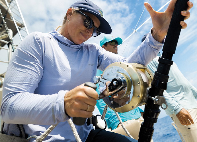A woman holding a fishing rod on a boat.