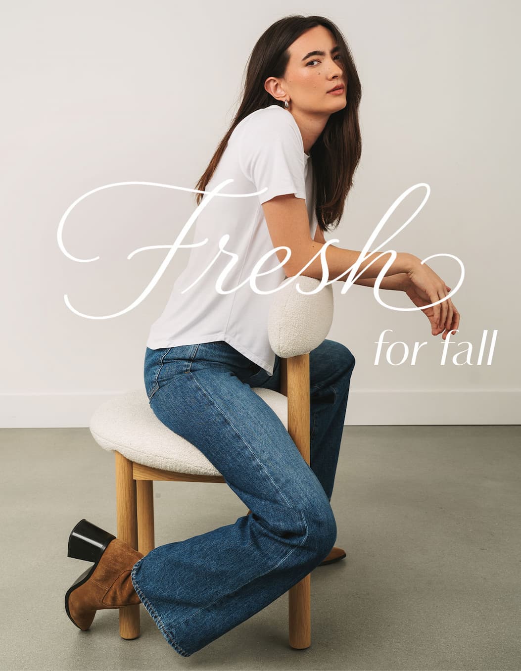 Minimal studio portrait of a model in a white tee and denim with script overlay: “Fresh for Fall.”