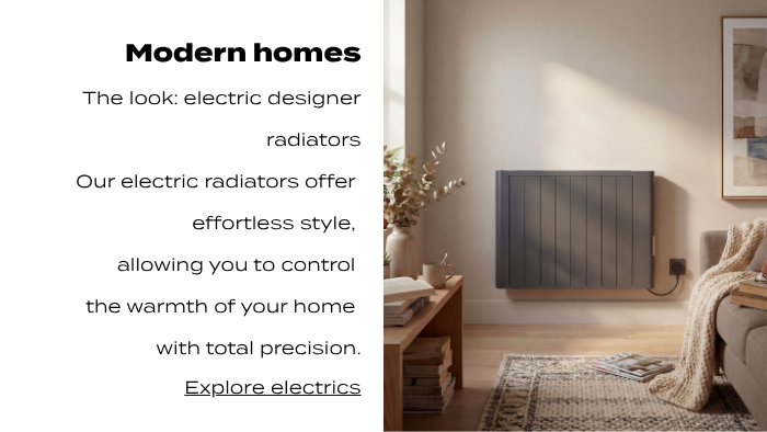 Dark grey electric designer radiator mounted on a contemporary living room wall with warm natural light and minimalist décor.