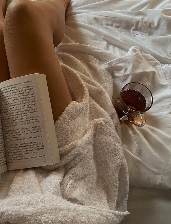 READING A BOOK IN BED WITH A TEA