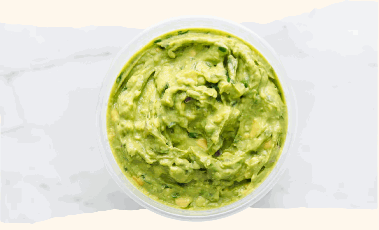 A bowl of fresh guacamole viewed from above on a marble surface