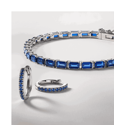 Blue gemstone tennis bracelet paired with matching white metal hoop earrings.