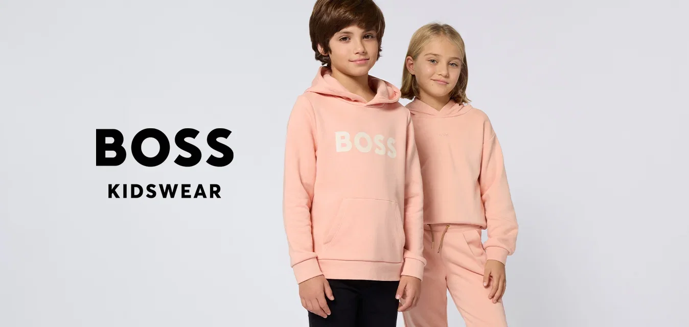 Dos niños de pie uno al lado del otro con sudaderas con capucha de color melocotón, uno con el texto 