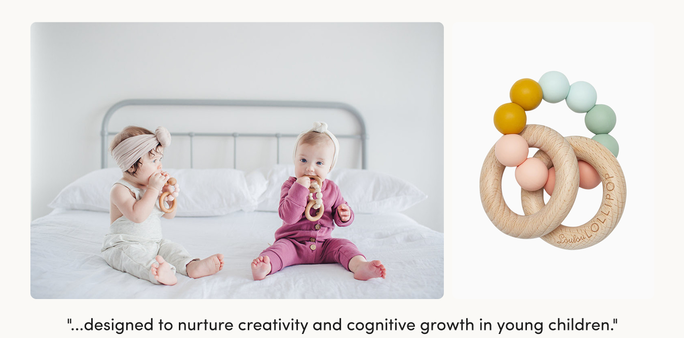 two babies sitting on a bed chewing on wood and silicone ring teethers