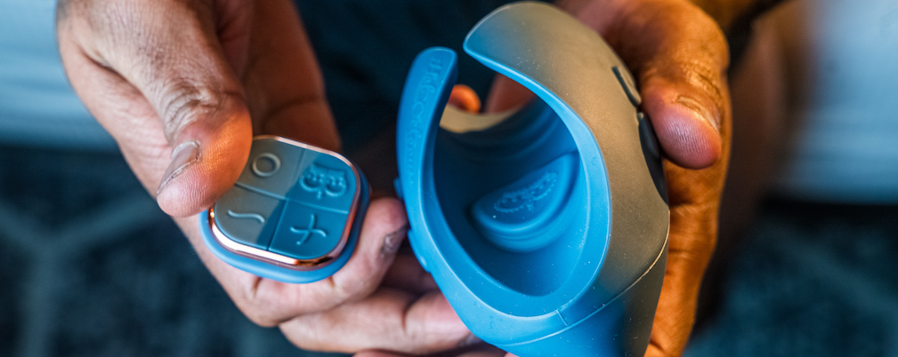 Man's hands holding Pulse DUO and its remote