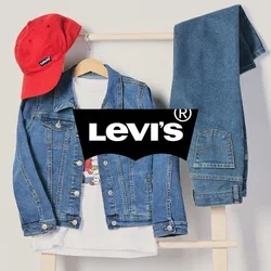 Rode pet, spijkerjack over een wit T-shirt en opgevouwen blauwe spijkerbroek hangen aan een houten rek tegen een effen achtergrond.