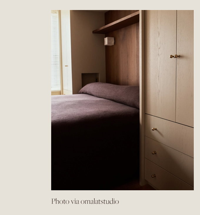 Plum blanket covering a bed in a room with wooden cabinets