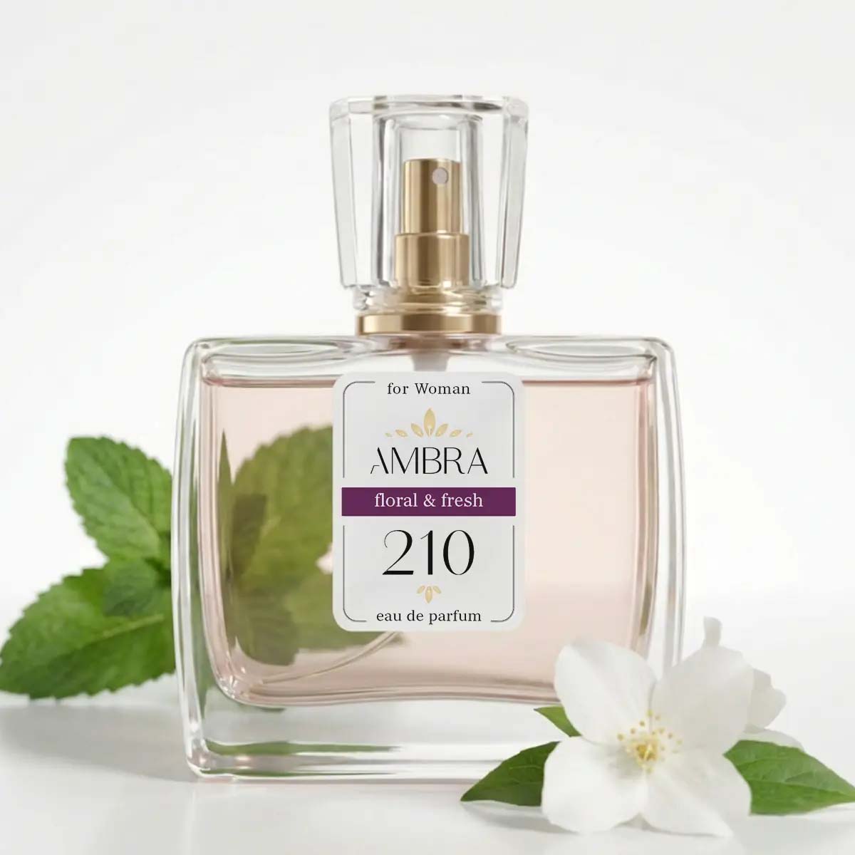 Glass perfume bottle labelled Ambra 210 floral & fresh eau de parfum beside a white jasmine flower and mint leaves