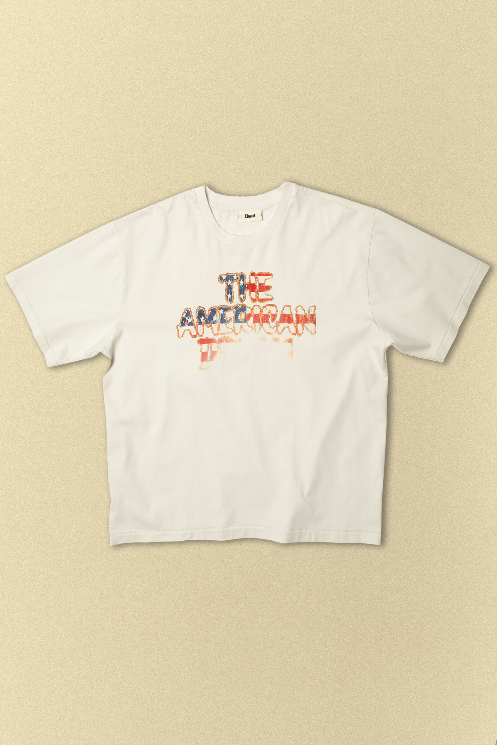 A faded "The American Dream" graphic screenprinted on the Oversized Core Tee in off white. 