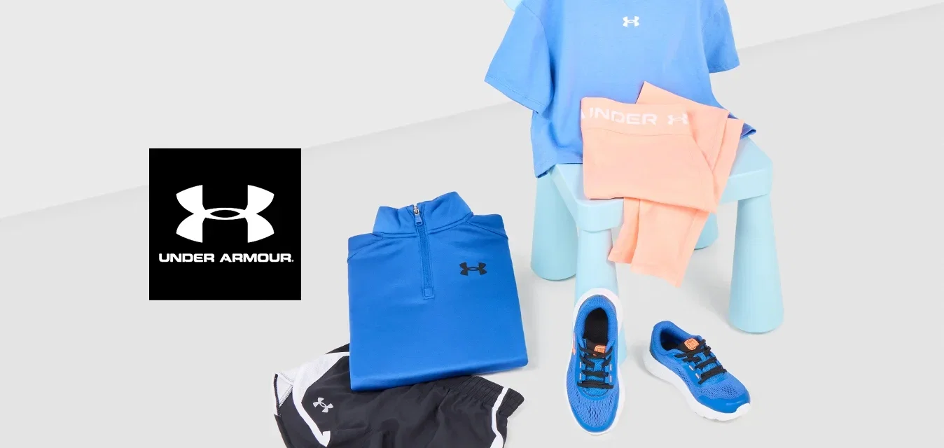 Ropa deportiva azul y melocotón sobre una pequeña silla azul con pantalones cortos negros, camiseta azul y zapatillas azules sobre una superficie blanca.