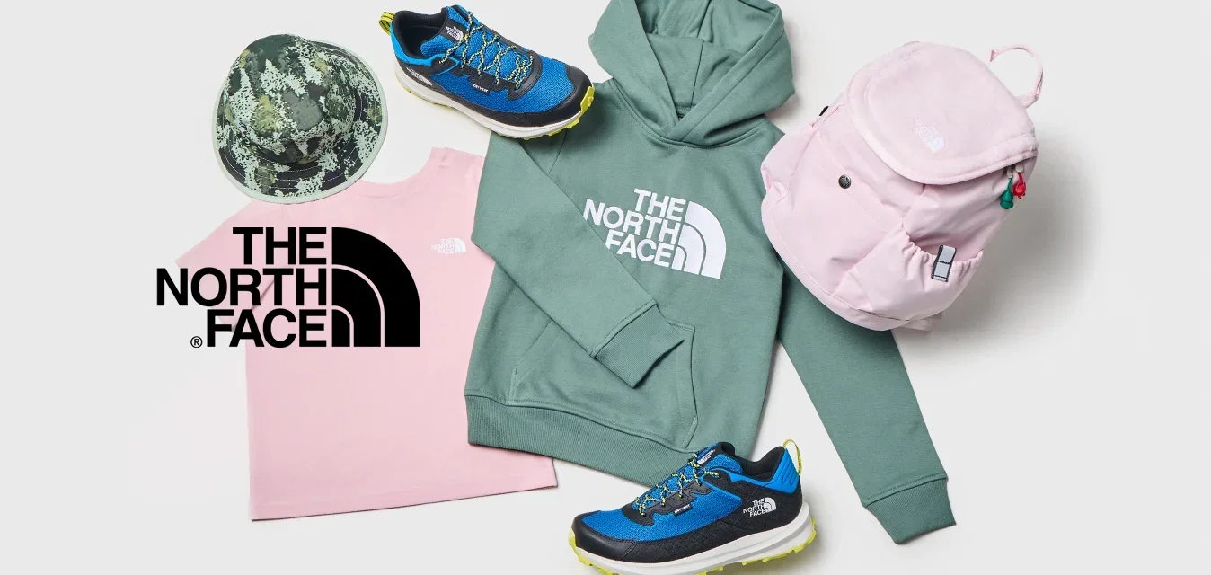 Sudadera verde de North Face, camiseta rosa de North Face, gorra de camuflaje, mochila rosa y zapatillas azules organizadas sobre un fondo blanco.