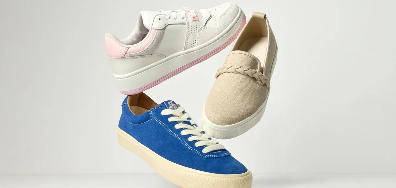 Tres zapatos flotantes: unas zapatillas blancas y rosas, un zapato beige tipo slip-on con detalle trenzado, y unas zapatillas azul con cordones y suela crema, sobre un fondo claro.