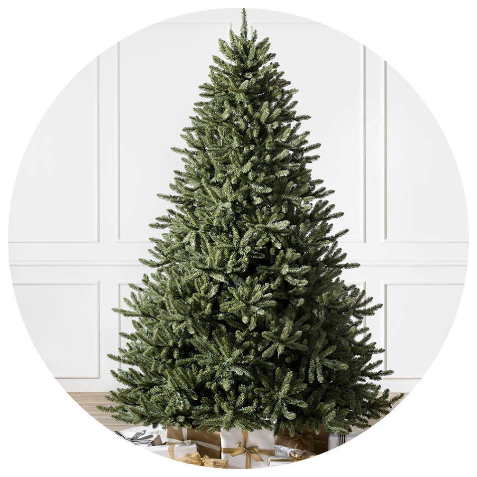 Full view of a lush artificial Christmas tree in a clean indoor setting.