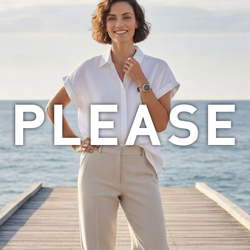 Smiling woman on a wooden jetty by the sea wearing a white blouse and beige trousers, hand on hip, with large 'PLEASE' text overlay