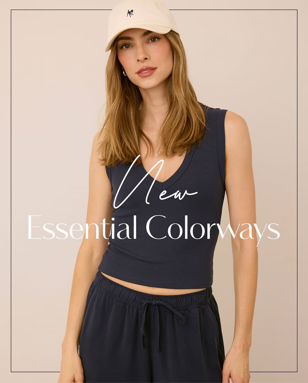 Model in a navy ribbed tank, matching pants and white cap. Text: “New Essential Colorways.”