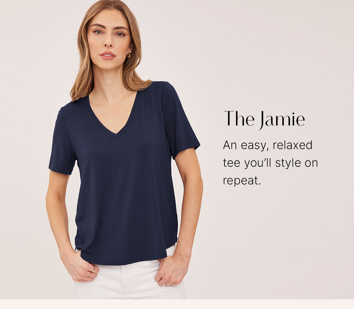 Model wears a navy V-neck Jamie T-shirt with white pants. Text calls it an easy, relaxed tee.