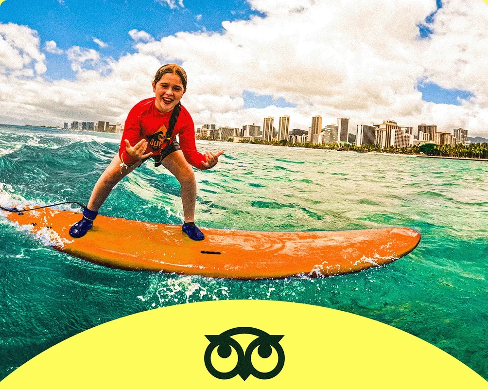 Descripción de la imagen: Una persona surfeando en el mar con una ciudad de fondo.