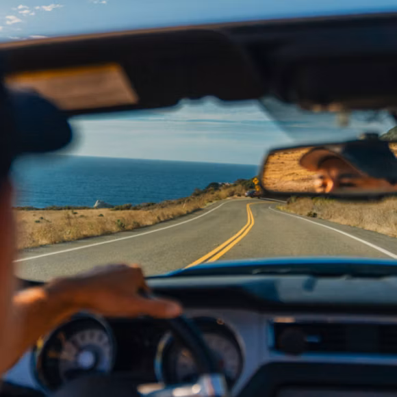 Look through windscreen of car driving along Pacific Coast Highway, linking to BA High Life site.