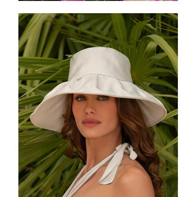 A woman in a colorful floral dress wearing a straw hat, and another woman in a white hat.