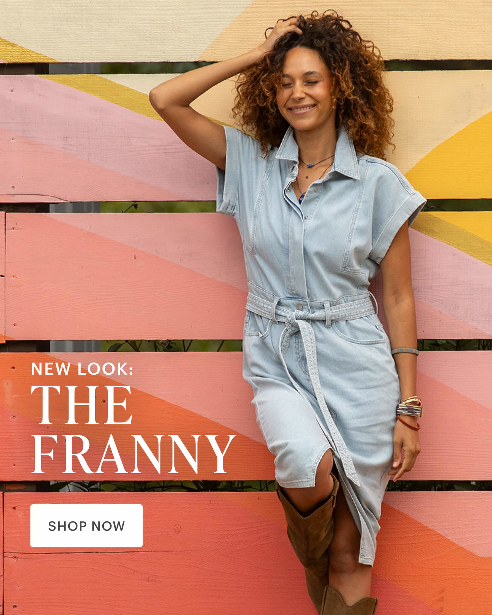 New Look: The Franny. Woman in a lightweight denim dress and high boots standing in front of red and yellow painted wall. 