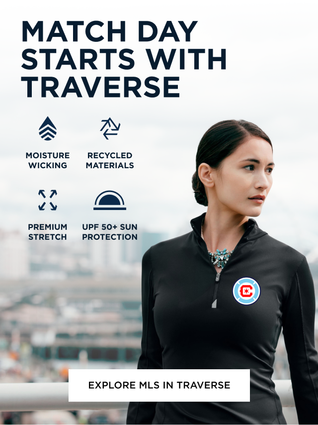 Woman wearing black Traverse zip up sweater looking over the city skyline | Explore Traverse