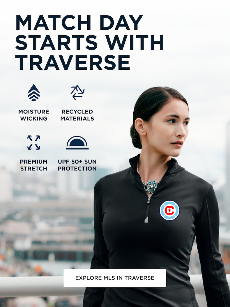 Woman wearing black Traverse zip up sweater looking over the city skyline | Explore Traverse