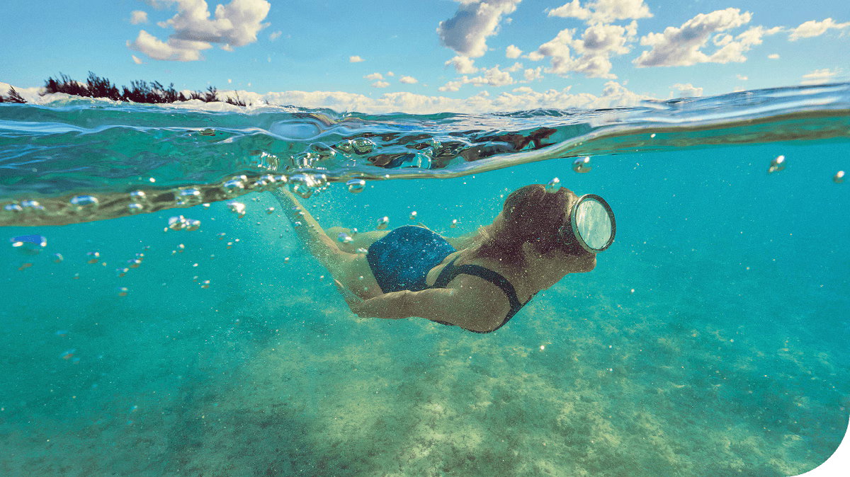A guest swims in the clear blue waters of Celebration Key, Caribbean.
