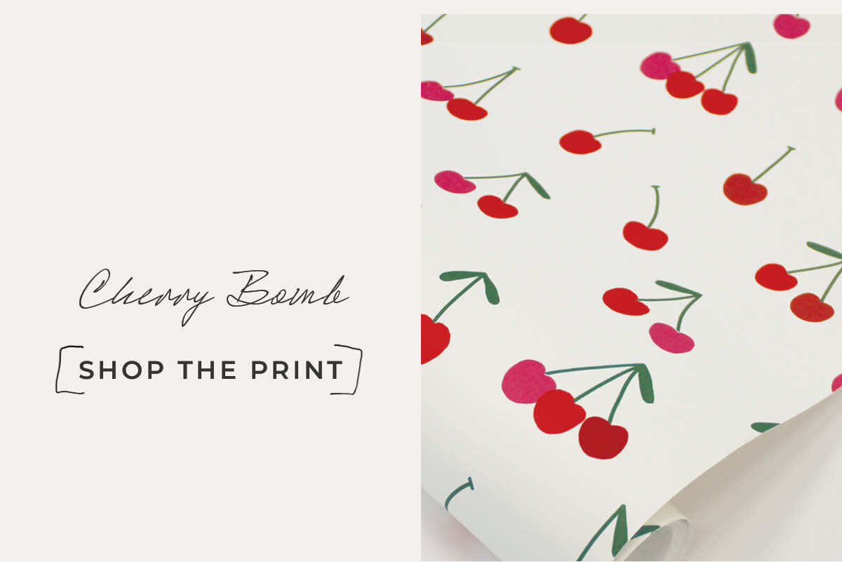 Image of a roll of Tempaper's Cherry Bomb wallpaper next to a text box with "Cherry Bomb. Shop the Print"