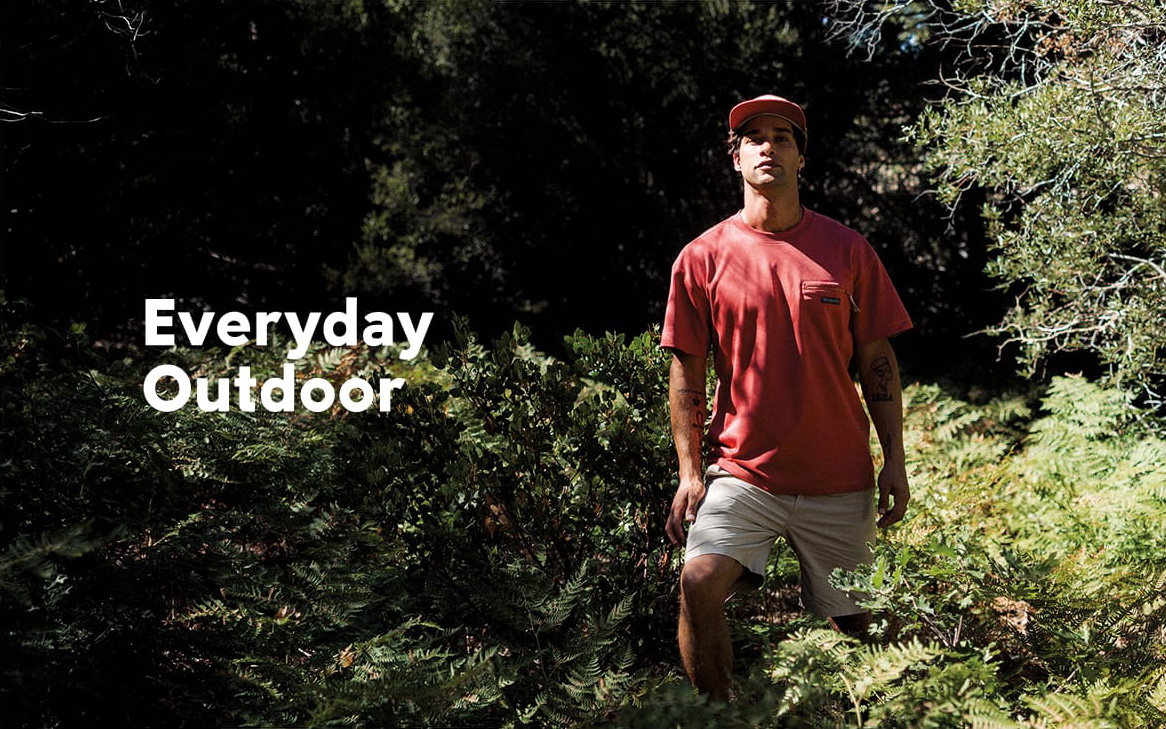 A man standing in a forest with text: Everyday Outdoor