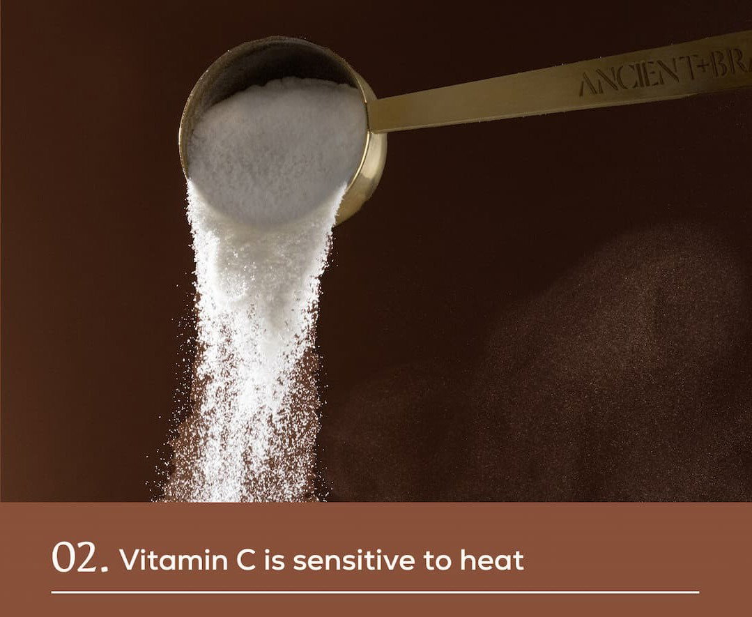 An Ancient + Brave measuring scoop pouring white powder against a dark brown background. 02. Vitamin C is sensitive to heat.