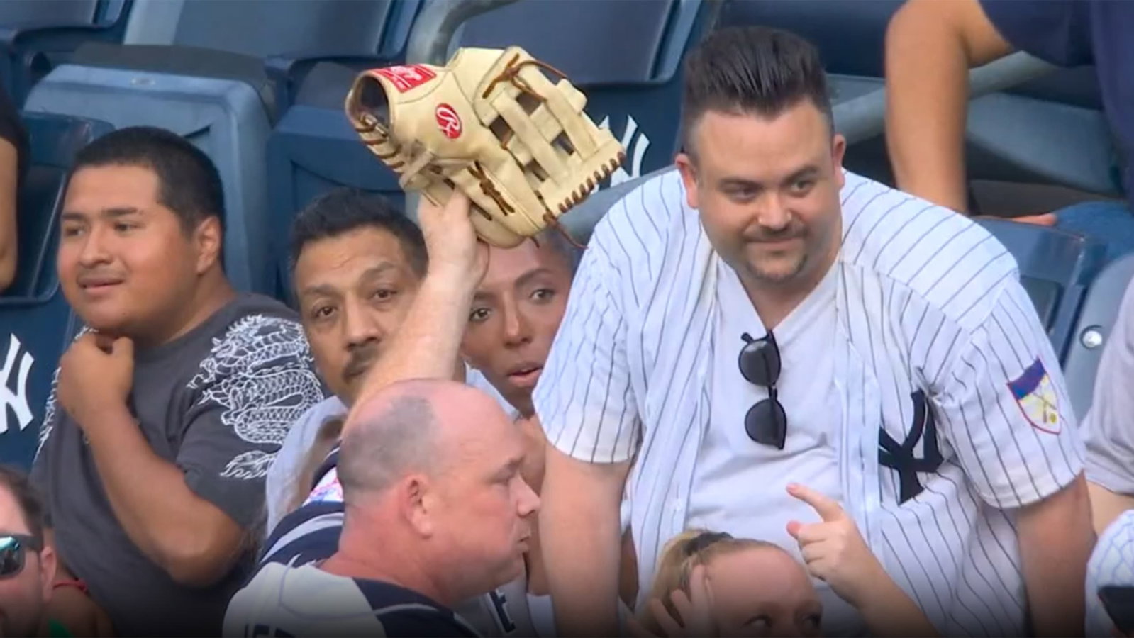 A Yankees fan holds up a glove in the stands