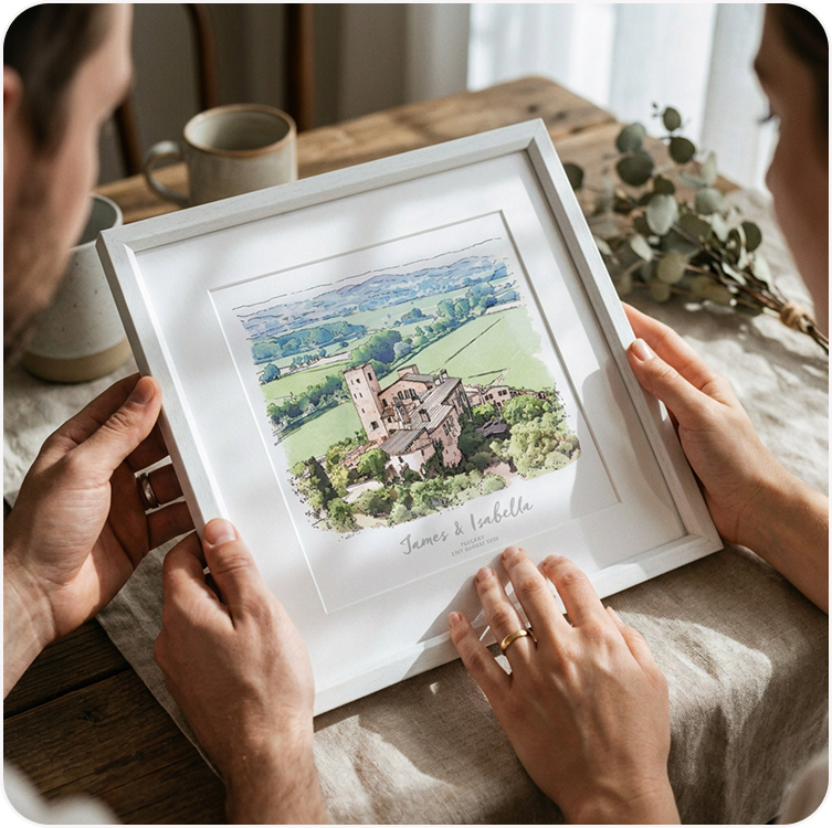 A couple looking together at a framed watercolour illustration, personalised with their names