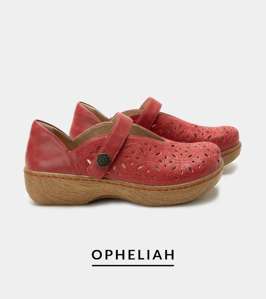 A side profile view of a pair of "Opheliah" red leather shoes. The upper features intricate laser-cut floral perforations, a single instep strap with a decorative dark metal button, and a classic light-toned wood-grain look rocker outsole.