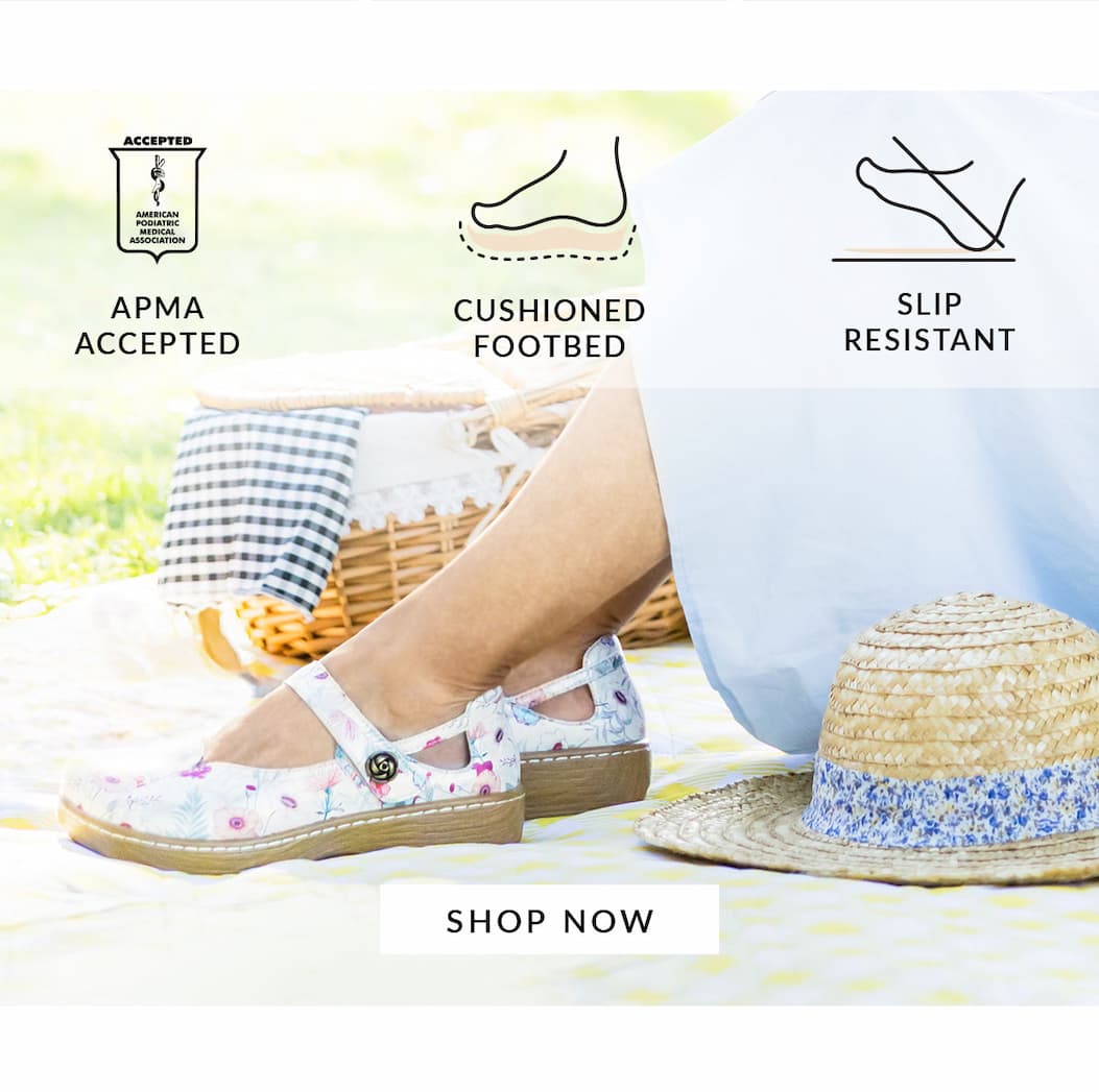A close-up image focusing on a woman's legs and feet on a picnic. She is wearing floral print Alegria Onika Ethereal Mary Jane shoes with a wood-look rocker sole. Icons above indicate "APMA ACCEPTED", "CUSHIONED FOOTBED", and "SLIP RESISTANT". A "SHOP NOW" button sits at the bottom.