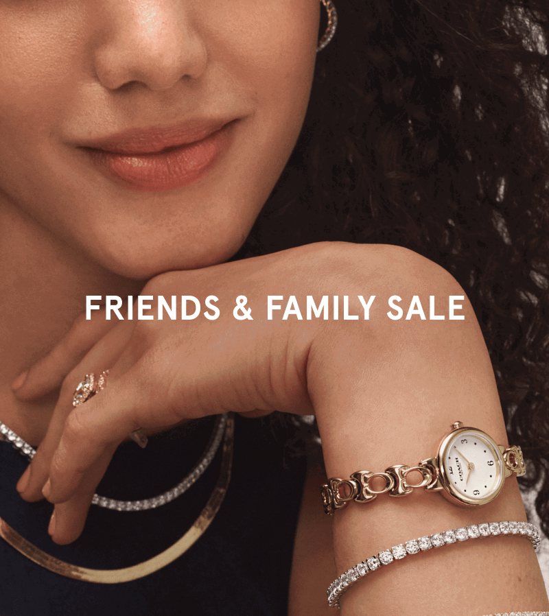 Woman wearing diamond hoops, layered necklaces, stacked diamond rings, bracelets and a gold watch. Friends and family sale.