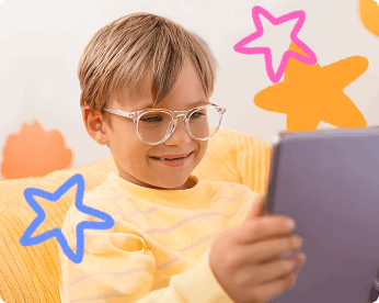 Kid with glasses smiling at computer