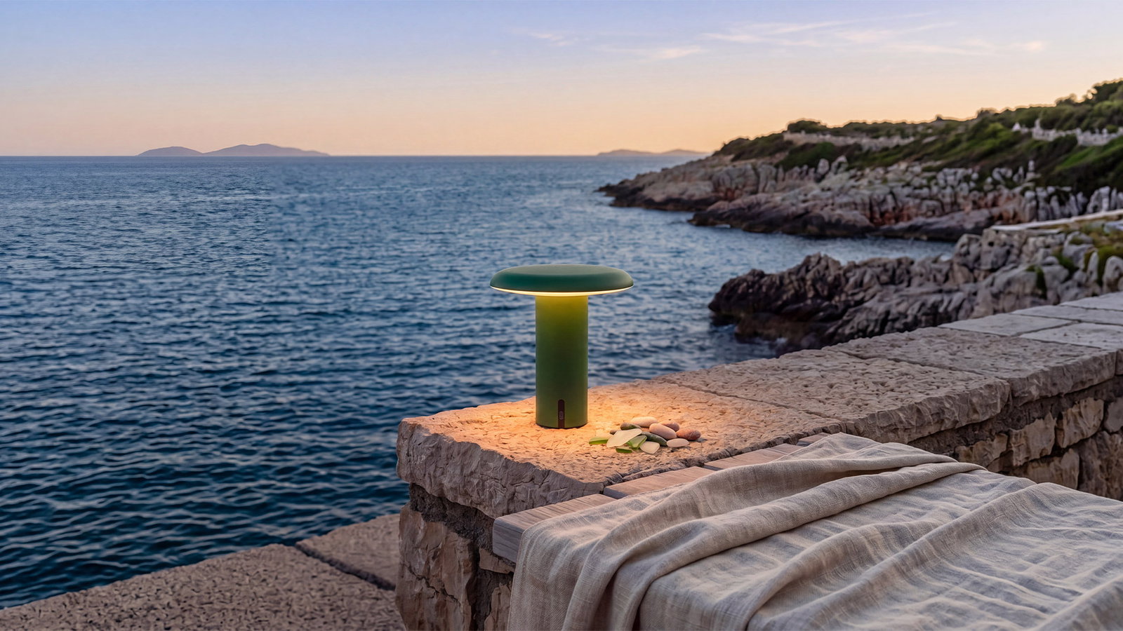 Artemide Takku portable lamp overlooking the sea at sunset