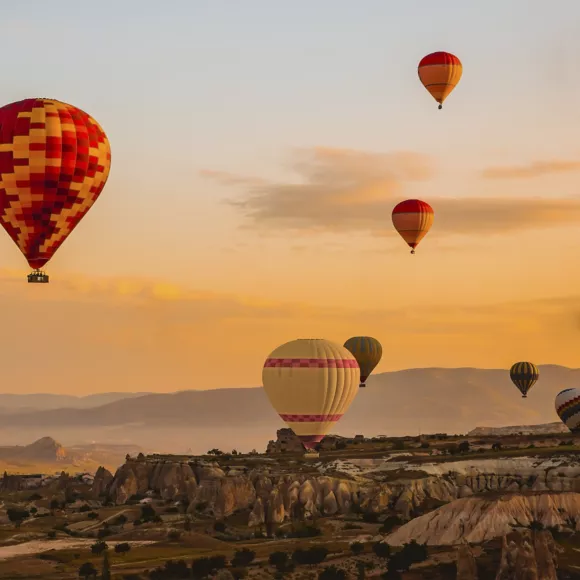 Hot air balloon flying over Cappadocia region in Turkey. Linking to ba.com.