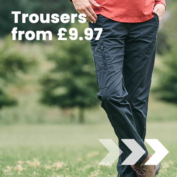 Person walks across a grassy outdoor area wearing hiking trousers, promoting Peter Storm trousers from £9.97.